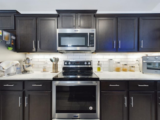 kitchen featuring dark brown cabinetry, stainless steel appliances, and decorative backsplash