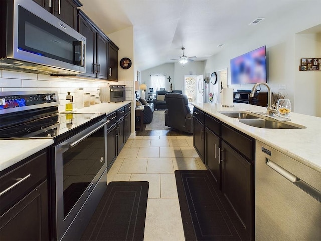 kitchen with sink, ceiling fan, appliances with stainless steel finishes, tasteful backsplash, and light tile patterned flooring