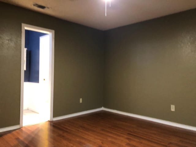 spare room with dark wood-type flooring