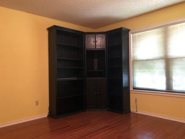 empty room featuring dark hardwood / wood-style floors and a textured ceiling