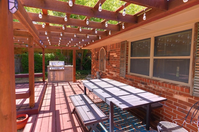 wooden deck with a pergola, grilling area, and exterior kitchen