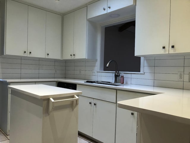 kitchen featuring white cabinetry, sink, and tasteful backsplash