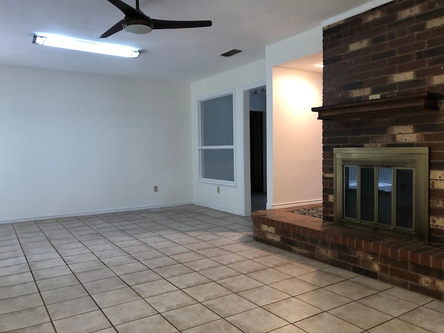 unfurnished living room with a brick fireplace and ceiling fan