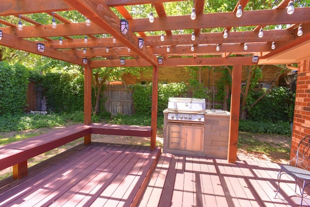 deck featuring exterior kitchen, a grill, and a pergola