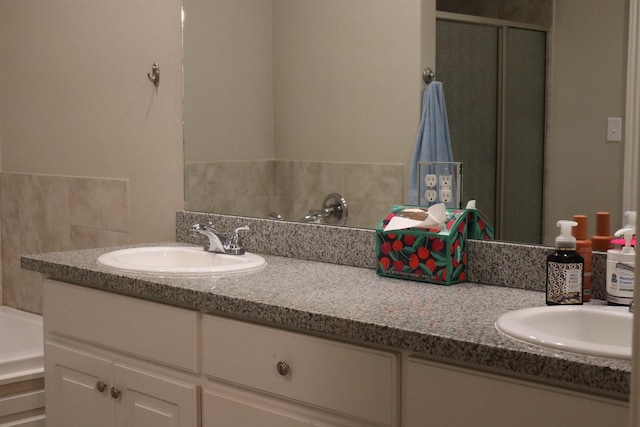 bathroom featuring a shower with door and vanity