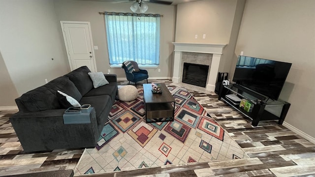 living room with ceiling fan and a fireplace