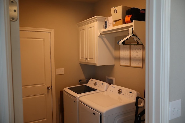 clothes washing area with cabinets and independent washer and dryer