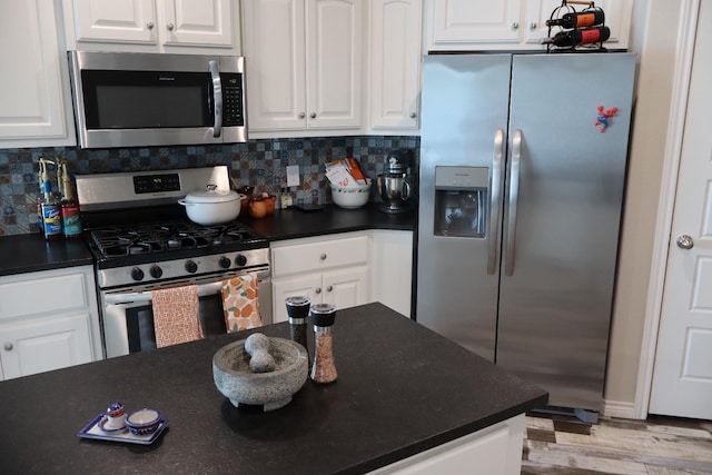 kitchen featuring appliances with stainless steel finishes, light hardwood / wood-style floors, decorative backsplash, and white cabinets