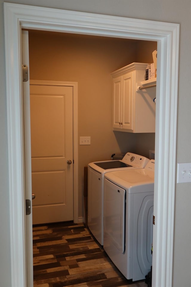 laundry room with cabinets, dark hardwood / wood-style floors, and washing machine and clothes dryer