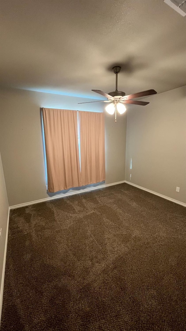 carpeted spare room featuring ceiling fan and a textured ceiling