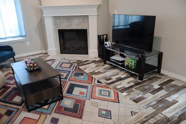 living room featuring a tiled fireplace and wood-type flooring