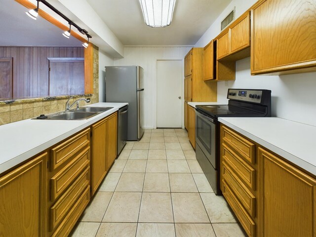 kitchen featuring sink, light tile patterned floors, stainless steel appliances, and decorative backsplash