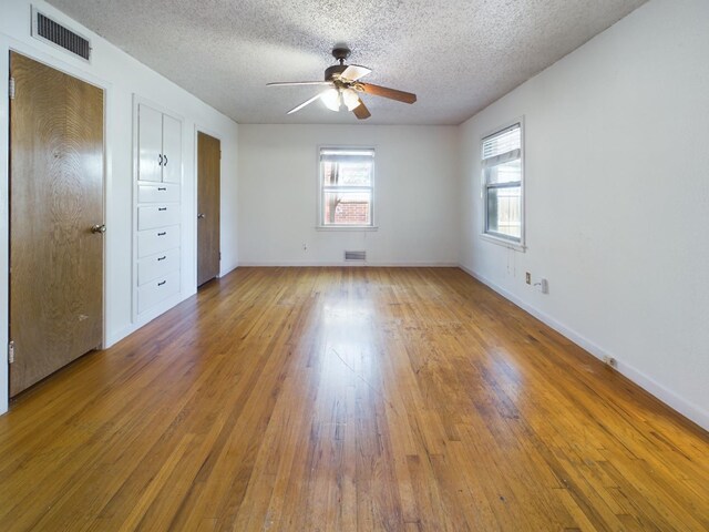 unfurnished bedroom with ceiling fan, hardwood / wood-style flooring, and a textured ceiling