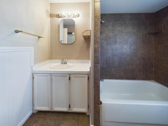 bathroom featuring tiled shower / bath combo and vanity