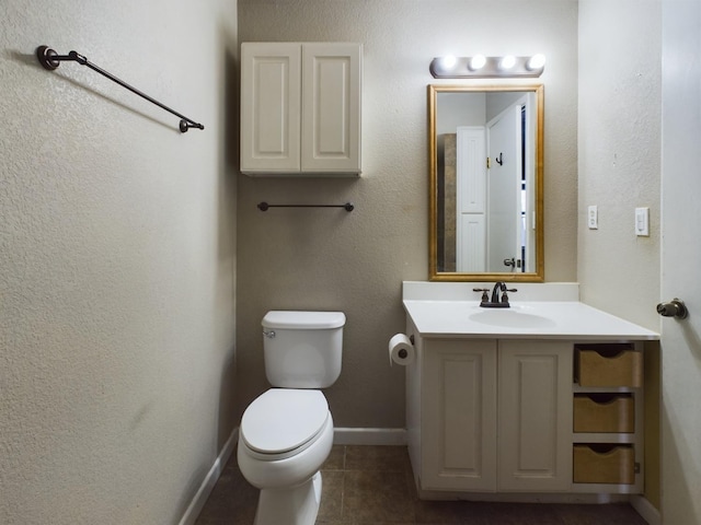 bathroom featuring vanity, tile patterned flooring, and toilet