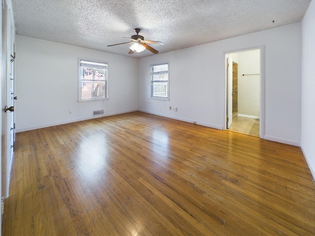 unfurnished bedroom with ceiling fan, a textured ceiling, and light wood-type flooring