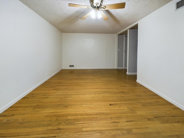 empty room with ceiling fan, a textured ceiling, and light hardwood / wood-style floors