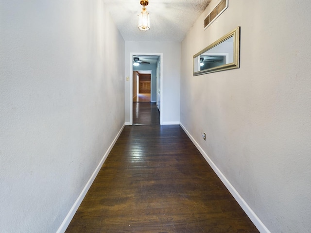 hall featuring dark hardwood / wood-style floors and a textured ceiling