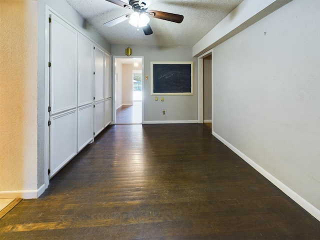 interior space with ceiling fan, a textured ceiling, and dark hardwood / wood-style flooring