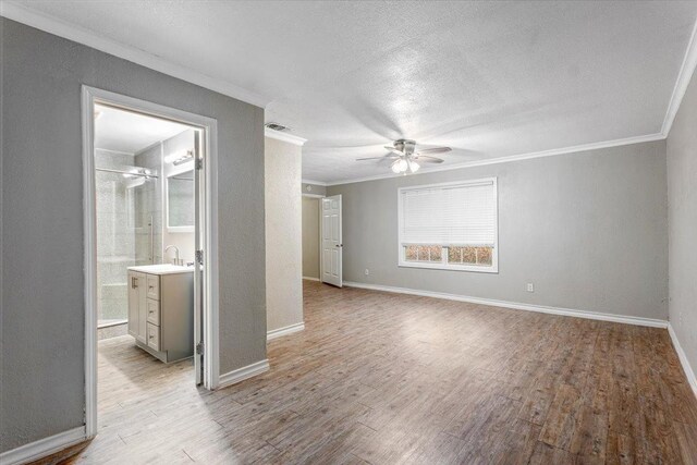 spare room featuring crown molding, ceiling fan, light hardwood / wood-style flooring, and a textured ceiling