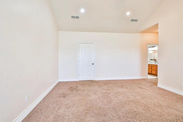 carpeted spare room with lofted ceiling