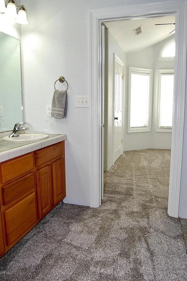 bathroom with lofted ceiling and vanity