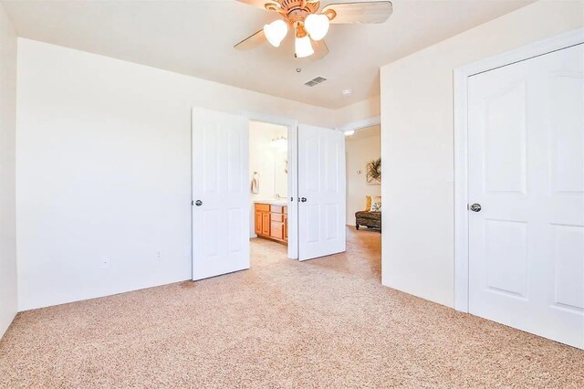 unfurnished bedroom featuring light colored carpet and ceiling fan