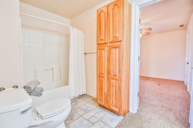 bathroom featuring shower / tub combo, ceiling fan, and toilet