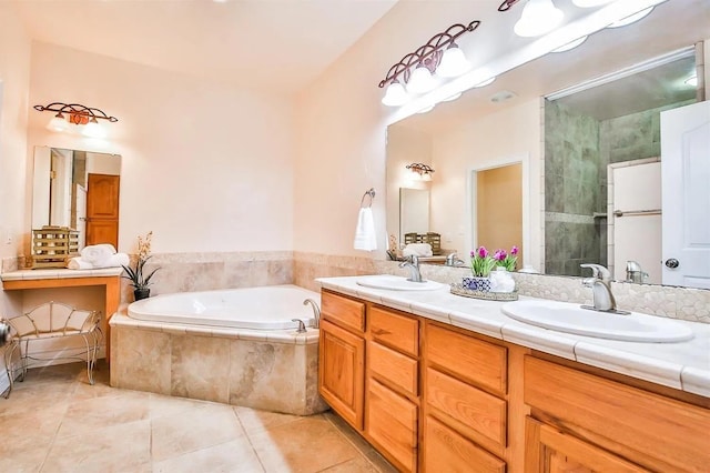 bathroom with vanity, a relaxing tiled tub, and tile patterned floors