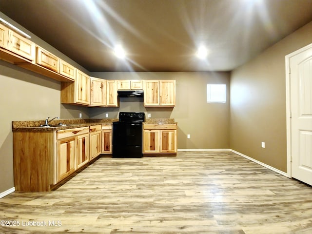 2834 E 7th St, Lubbock, TX 79403 - kitchen with black electric range, range hood, light wood-style flooring, and baseboards