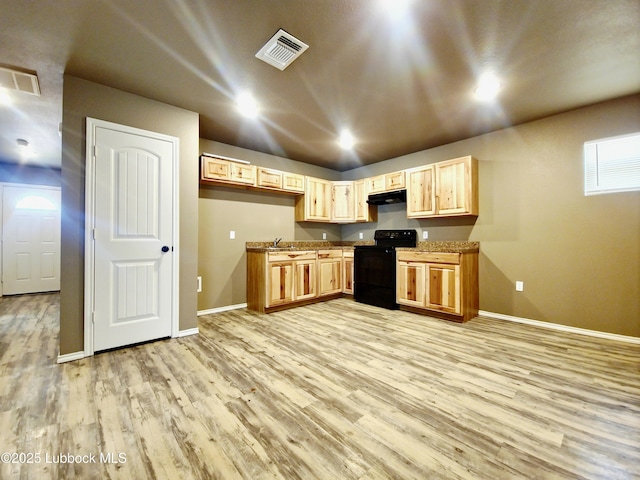 2834 E 7th St, Lubbock, TX 79403 - kitchen with black range oven, baseboards, light wood-style floors, light brown cabinets, and recessed lighting