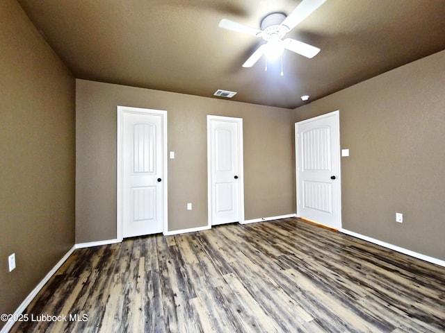 2834 E 7th St, Lubbock, TX 79403 - unfurnished bedroom featuring dark wood-style flooring, baseboards, and a ceiling fan