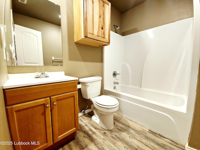 2834 E 7th St, Lubbock, TX 79403 - bathroom featuring wood finished floors, vanity, toilet, and  shower combination