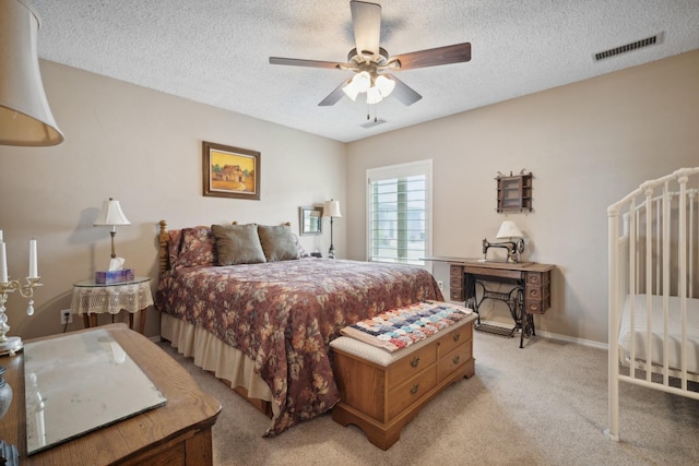 carpeted bedroom with ceiling fan and a textured ceiling