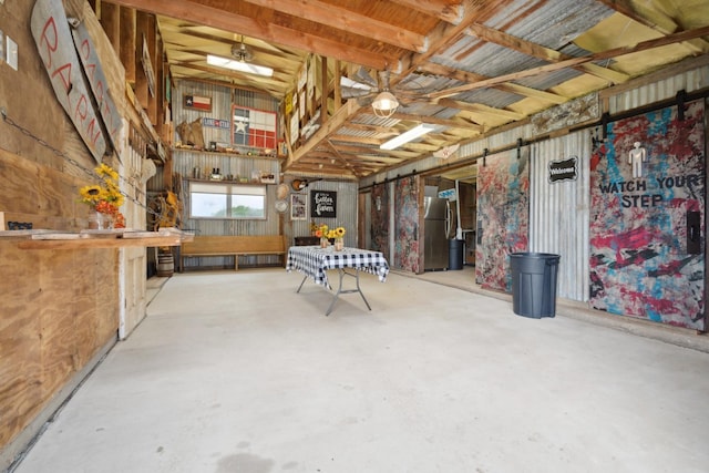 misc room featuring a barn door and concrete floors