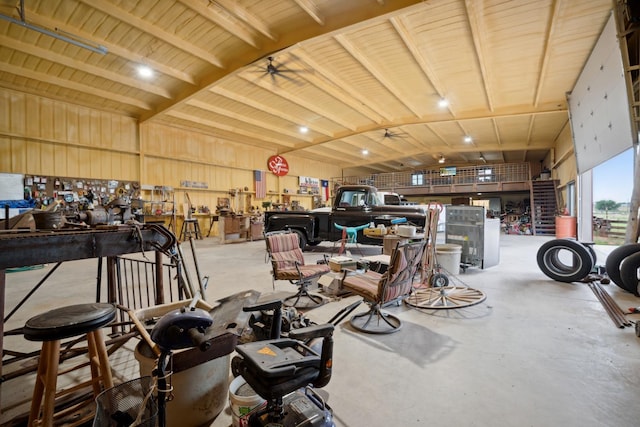 miscellaneous room featuring concrete flooring, vaulted ceiling, ceiling fan, and a workshop area