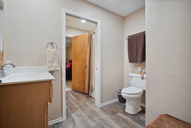 bathroom with vanity, wood-type flooring, and toilet