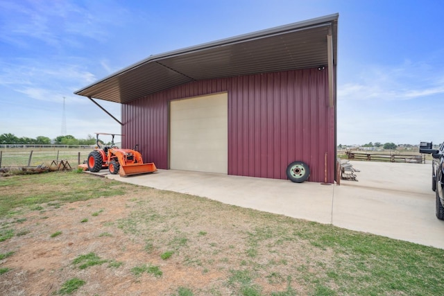 garage featuring a lawn and a rural view