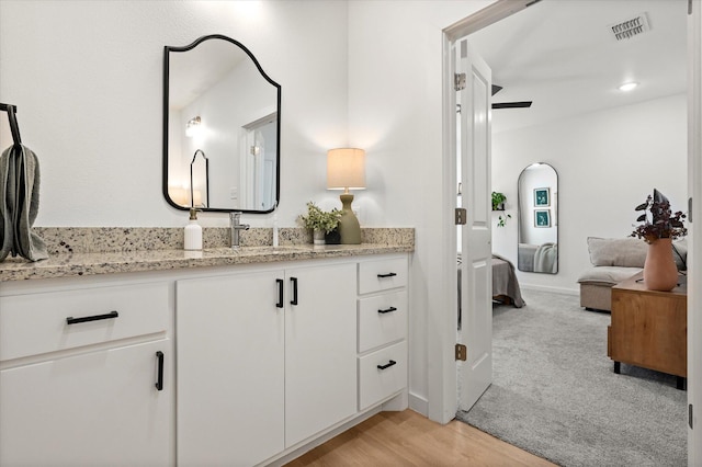 6937 12th St, Lubbock, TX 79416 - bathroom featuring ensuite bath, visible vents, vanity, and wood finished floors