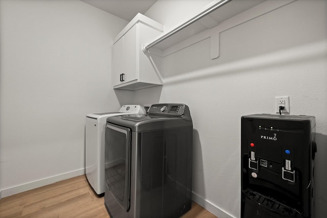 6937 12th St, Lubbock, TX 79416 - washroom featuring light wood finished floors, baseboards, washing machine and clothes dryer, and cabinet space