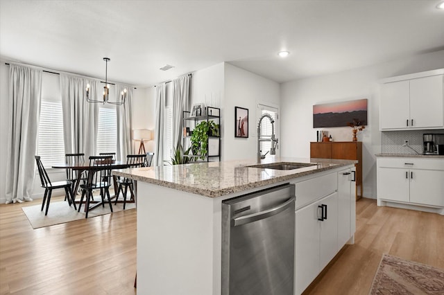 6937 12th St, Lubbock, TX 79416 - kitchen with light wood-type flooring, a chandelier, stainless steel dishwasher, backsplash, and a sink