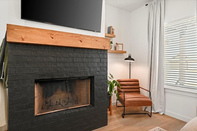 6937 12th St, Lubbock, TX 79416 - living area featuring baseboards, wood finished floors, and a brick fireplace