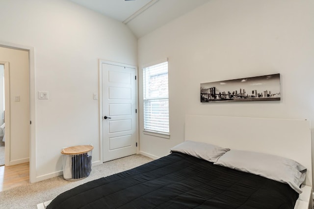 bedroom featuring light colored carpet and lofted ceiling