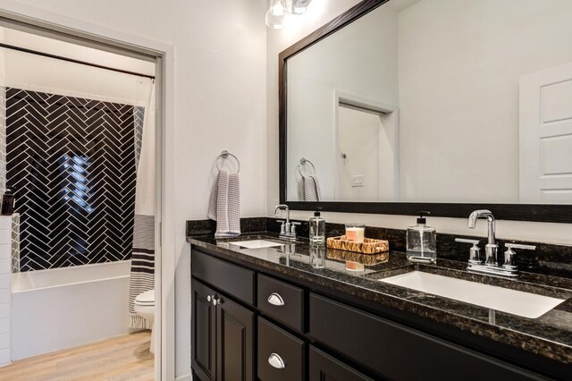 full bathroom featuring vanity, hardwood / wood-style flooring, toilet, and shower / bathtub combination with curtain