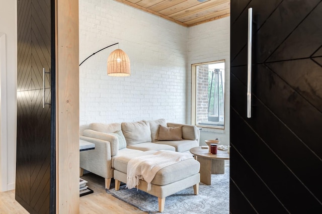 living room with light wood-type flooring, wooden ceiling, and brick wall