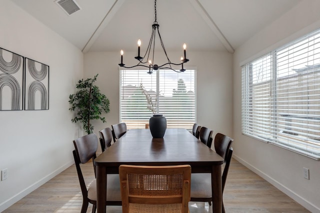 dining area featuring vaulted ceiling, a chandelier, and light hardwood / wood-style floors