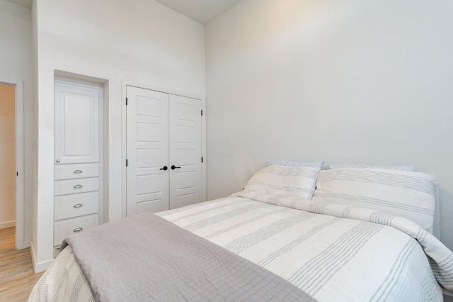 bedroom with light hardwood / wood-style floors and a closet