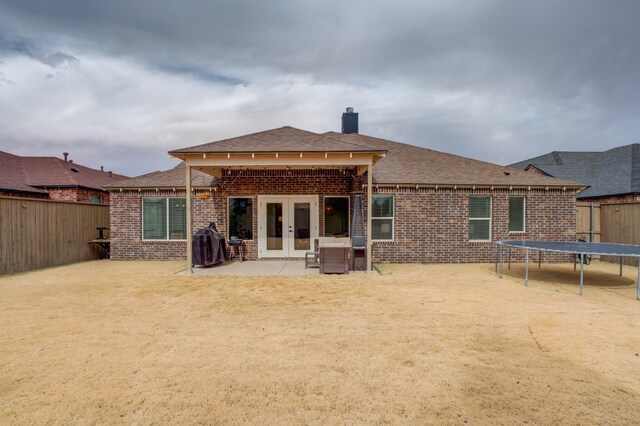 back of house with a trampoline, a patio, and french doors