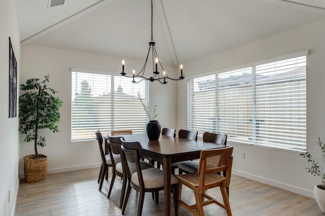 dining area with vaulted ceiling, a chandelier, and light wood-type flooring