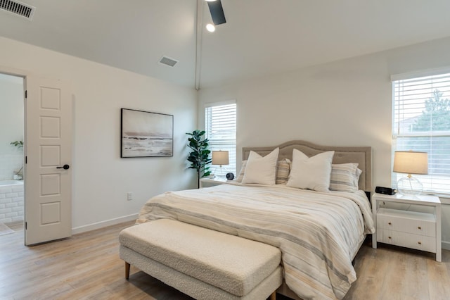 bedroom with ceiling fan, lofted ceiling, multiple windows, and light wood-type flooring